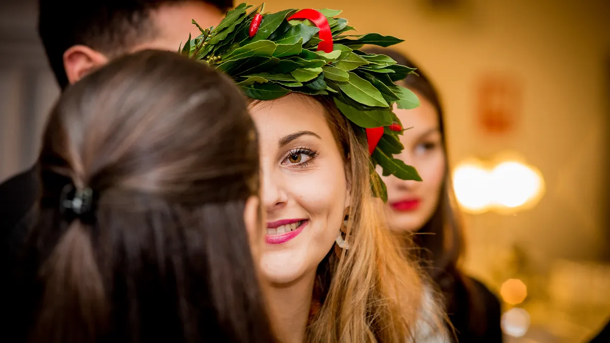Due amiche abbracciate alla festa di laurea, una porta la corona d'alloro