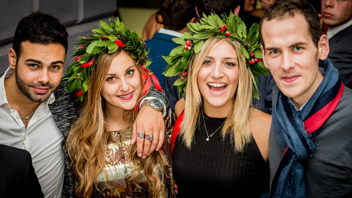 Gruppo di amici che festeggia la laurea, due con la corona d'alloro