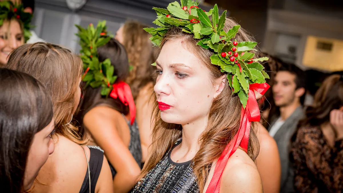La laureata di profilo in mezzo agli amici, corona d'alloro e nastro rosso