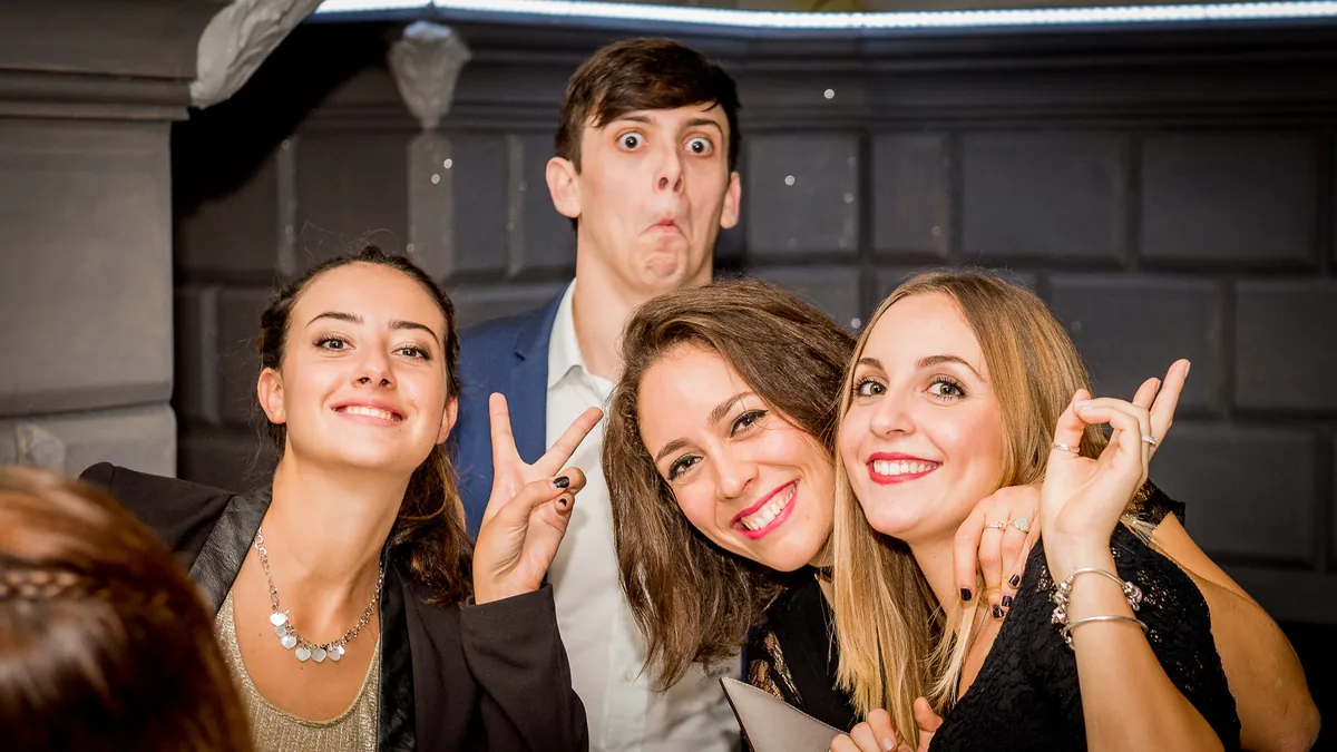 Tre amici fanno le facce buffe alla festa di laurea a Roma