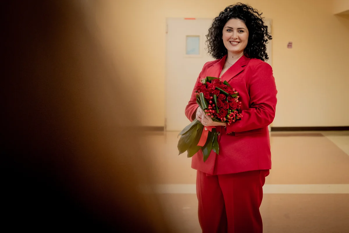 Ritratto della neolaureata con i fiori nei corridoi dell'università